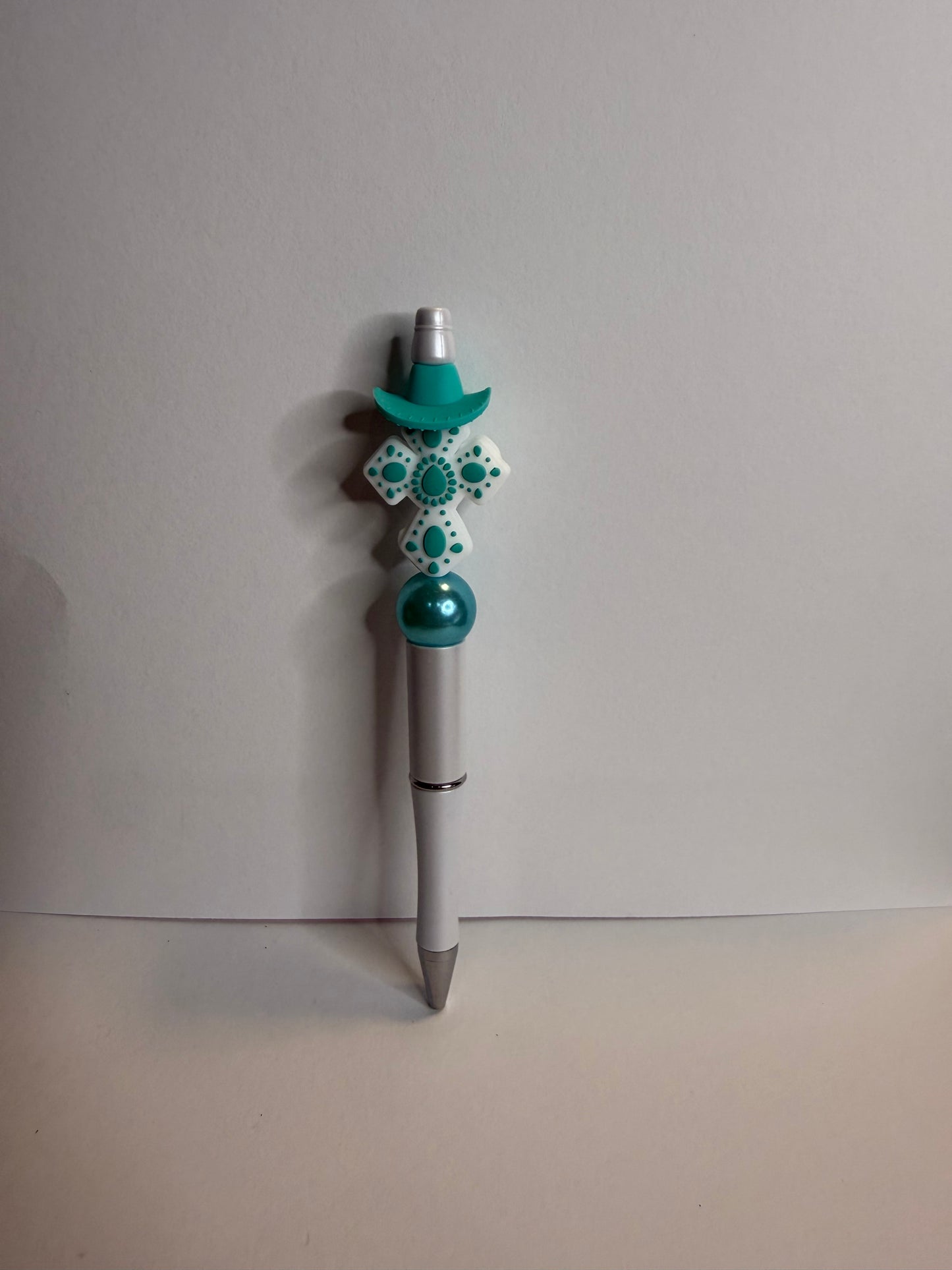 white and teal cross on white premade pen